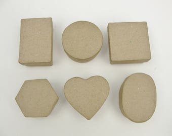 May include: Six cardboard boxes in different shapes: a rectangle, a circle, a heart, a hexagon, a square, and an oval. The boxes are all made of brown cardboard and have a rough texture.