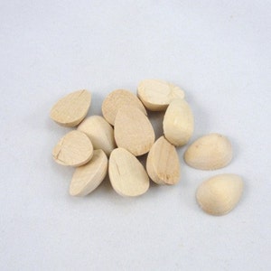 May include: A pile of unfinished wooden teardrop shapes, perfect for crafting projects.
