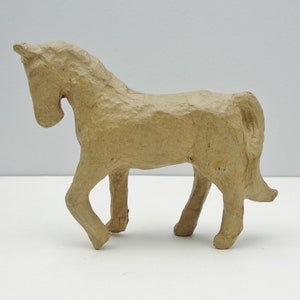 May include: A brown paper mache horse figurine. The horse is standing on all four legs and has a long tail.