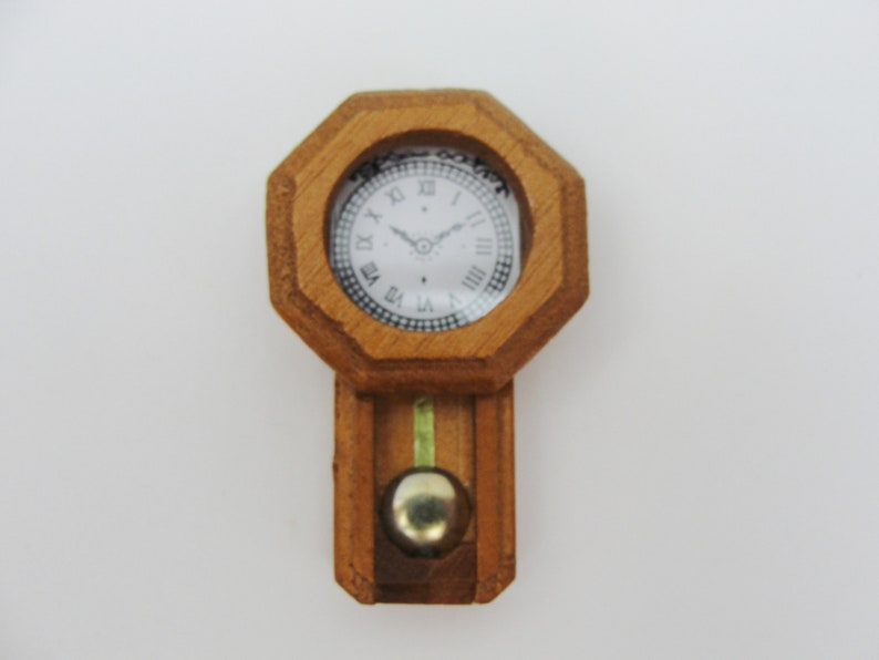 May include: A wooden clock with a white face and black Roman numeral markings. The clock has a pendulum and is in an octagonal shape.