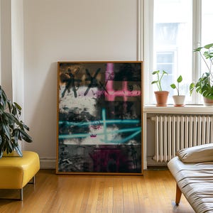 May include: Abstract art print in a wooden frame. The artwork features graffiti-style elements with black, pink, and teal colors. The design includes a crown, a smiley face, and other abstract shapes. The background is a mix of dark and light tones.