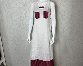 May include: A white linen maxi dress with a red and white striped trim at the bottom. The dress has two red and white striped pockets on the front.