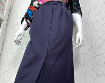 May include: A navy blue skirt with a front slit and a high waist, paired with a blouse featuring a colorful floral pattern in pink, red, blue, and black. The blouse has long sleeves.