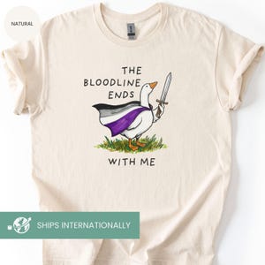 May include: Cream-colored t-shirt featuring a cartoon goose wearing a cape with the asexual pride flag colors and holding a sword. The text "THE BLOODLINE ENDS WITH ME" is printed above and below the goose illustration.