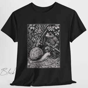 K&ouml;nnte beinhalten: Schwarzwei&szlig;illustration eines Frosches in R&uuml;stung, der ein Schwert h&auml;lt und einem Schnecken mit einer spiralf&ouml;rmigen Schale gegen&uuml;bersteht. Das Bild ist vor einem Hintergrund aus Laub dargestellt.