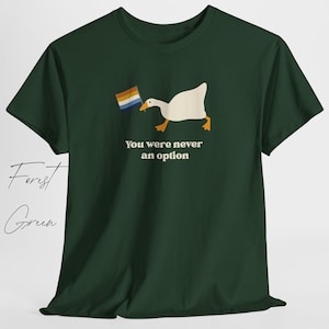 Op de afbeelding: Een bosgroen T-shirt met een witte gans die een regenboogvlag vasthoudt. De tekst "You were never an option" staat onder de gans.