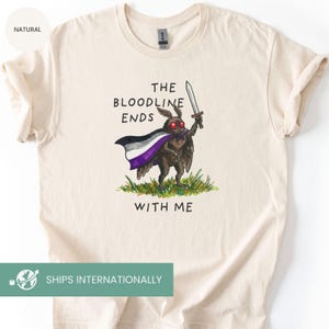 May include: Cream-colored t-shirt featuring a cartoon moth holding a sword and wearing a cape with the asexual pride flag colors. The text on the shirt reads "THE BLOODLINE ENDS WITH ME."