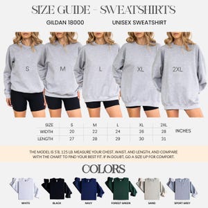 May include: A size guide for Gildan 18000 unisex sweatshirts. The image shows five models wearing gray sweatshirts in sizes S to 2XL. The chart provides measurements in inches for width and length. Available colors include white, black, navy, forest green, sand, and sport grey.