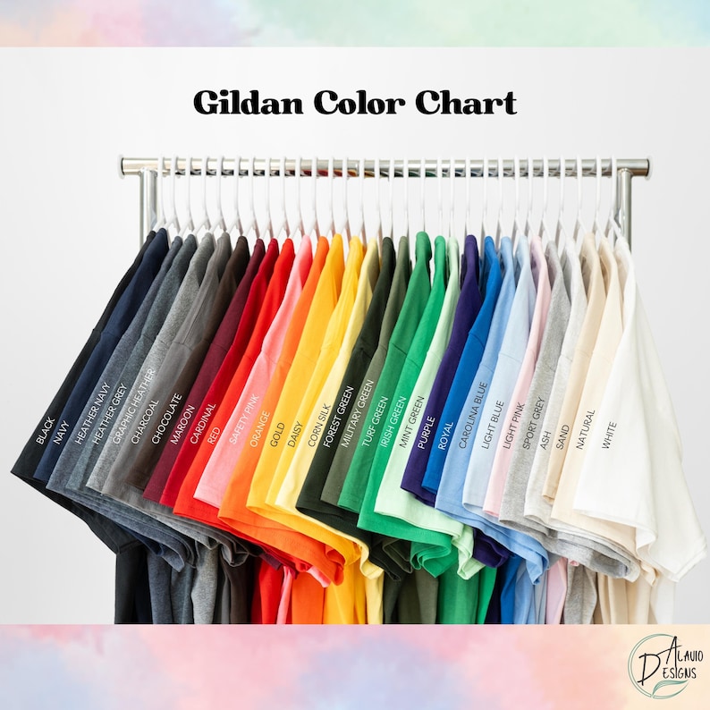 May include: A color chart of Gildan t-shirts, displayed on a metal rack. The shirts are arranged in a rainbow of colors, including black, navy, red, orange, yellow, green, blue, and pink. The text "Gildan Color Chart" is at the top.