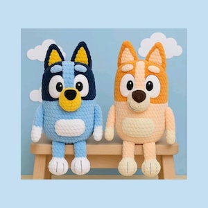 May include: Two plush toys featuring cartoon dog characters. The left toy is blue with dark blue ears and a yellow muzzle. The right toy is orange with a lighter orange muzzle and ears. Both have large white eyes, round noses, and white belly patches.