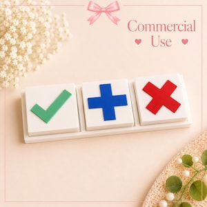 Può includere: Una base rettangolare bianca che sostiene tre blocchi quadrati bianchi. Il primo blocco presenta un segno di spunta verde, il secondo un segno più blu e il terzo una X rossa. Sopra, il testo recita Commercial Use con un fiocco rosa.