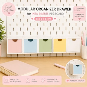 Op de afbeelding: Een set van vijf modulaire lade-organizers voor een IKEA SKÅDIS pegboard, elk 8 x 8 x 8 cm groot. De lades hebben pastelkleurige fronten in roze, blauw, groen, geel en wit, voorzien van een halfronde uitsparing om ze te openen.