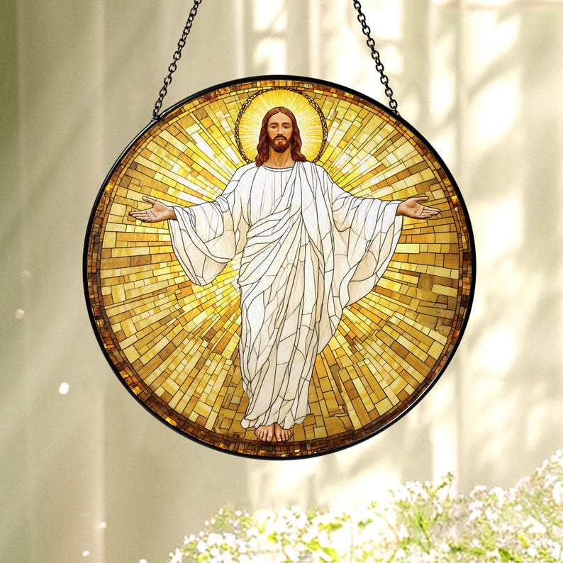 May include: A round stained glass window depicting a figure with outstretched arms, wearing a white robe, and surrounded by a golden halo. The mosaic-style background radiates light. The window is framed in black and suspended by a chain.