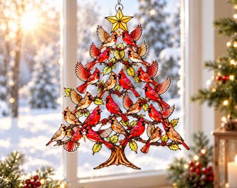 May include: A stained glass suncatcher shaped like a Christmas tree, featuring numerous red cardinal birds perched on branches with green leaves and red berries. A yellow star sits at the top, and the entire piece hangs from a metal chain.
