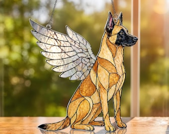 May include: Stained glass dog with angel wings, in tan and black. The dog is seated, with detailed wing design. The piece hangs from a chain, suitable for window or wall decoration. A decorative item.