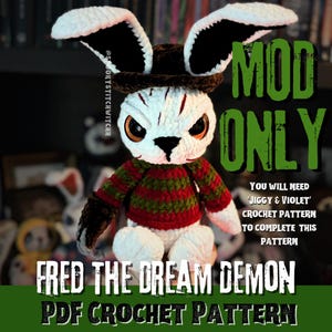 May include: A white and black crochet bunny with a brown hat and a red and green striped sweater. The bunny has large orange eyes and the text "FRED THE DREAM DEMON PDF CROCHET PATTERN" is displayed.