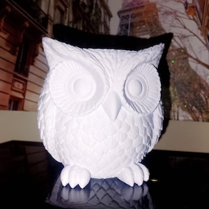 Könnte beinhalten: Ein Set aus drei Keramikbechern mit gesprenkelter, matter Oberfläche. Die Becher sind in Creme-, Hellgrau- und Dunkelgrautönen gehalten. Jeder Becher hat ein schlichtes, minimalistisches Design und einen abgerundeten Griff.