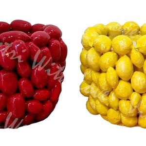 Könnte beinhalten: Vier Keramik-Blumentöpfe, jeder mit einem anderen Design. Der erste Topf ist rot und in Form einer Beeren-Traube. Der zweite Topf ist gelb und in Form einer Zitronen-Traube. Der dritte Topf ist rot und in Form einer Chilischoten-Traube. Der vierte Topf ist grün und in Form einer Limetten-Traube.