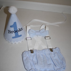 Boys first birthday cake smash outfit. Birthday hat, bow tie, suspenders and diaper cover available.  Personalized birthday hat with number and name. Baby Blue seersucker fabric with white suspenders and hat accents.