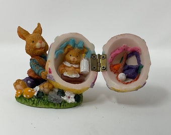 Vintage Easter Figurine. Boy bunny pushing baby bunny in an egg.