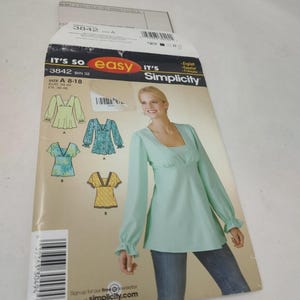 May include: A Simplicity sewing pattern packet, featuring a woman wearing a mint green top. The packet includes illustrations of different top styles, with the text "IT'S SO easy" and "Simplicity". Size A 8-18.