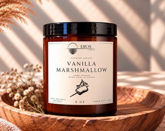 May include: An 8 oz amber glass jar candle with a black lid and a white label. The label features the text EROS CANDLES, VANILLA MARSHMALLOW, HAND POURED, BURN TIME: 40 HOURS, 100% NATURAL SOYWAX, MADE WITH LOVE, and a graphic of a toasted marshmallow.
