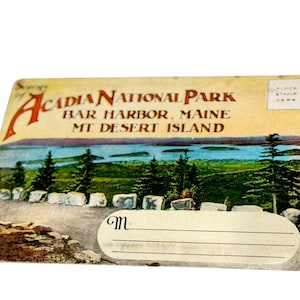 May include: Vintage postcard featuring Acadia National Park in Bar Harbor, Maine. The image shows a scenic view of the park with trees, water, and a road. The postcard has a space for a message and a stamp.