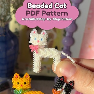 May include: Three small cat figures crafted from tiny beads. One is white with a pink bow, one is orange with a green bow, and one is black and white with an orange bow. Text at the top reads: Beaded Cat PDF Pattern A Detailed Step-by-Step Pattern.