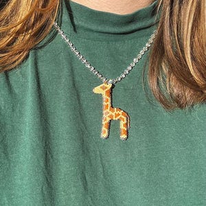 May include: A white ceramic mug with a black handle and the text "But First, Coffee" in a bold, black font. The mug is set against a blurred background, suggesting a cozy setting. The mug appears to be approximately 4 inches tall.