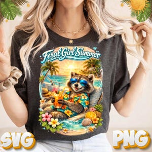 Peut inclure: T-shirt gris foncé avec un raton laveur portant des lunettes de soleil et une chemise hawaïenne, se relaxant sur une plage avec un cocktail. Le texte "Feral Girl Summer" est arqué au-dessus du raton laveur. Des fleurs et des fruits tropicaux entourent le raton laveur.