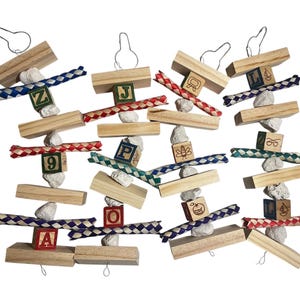 Puede incluir: Juguetes para pájaros de bloques de madera, piedras pequeñas y cuerda trenzada de colores. Cada juguete tiene un gancho de metal para colgar y bloques con letras o números. Un juguete divertido y atractivo para pájaros.