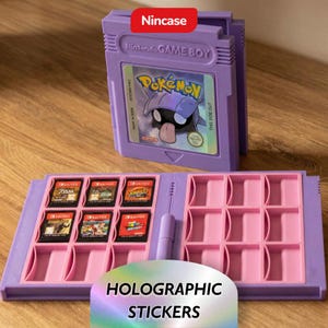 Op de afbeelding: Een paarse Nintendo Game Boy cartridge-vormige case met een roze interieur, met daarin verschillende game cartridges. De case heeft de tekst "Nincase" en "Nintendo GAME BOY". De case is open, met game cartridges en lege slots. Holografische stickers zijn ook zichtbaar.