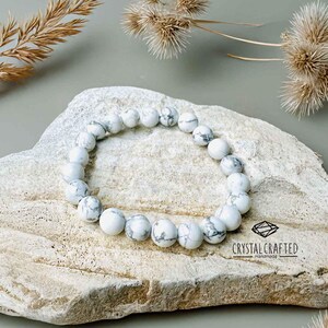 Close-up of a Howlite gemstone bracelet, showcasing white and gray-veined beads on a stretch cord. Perfect for meditation and relaxation.