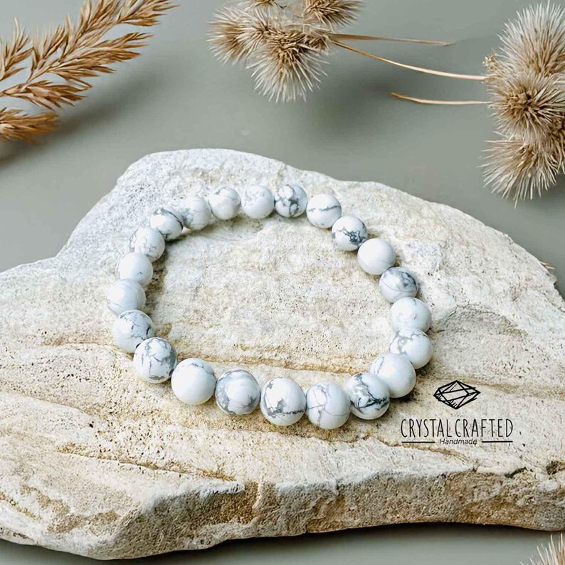 Close-up of a Howlite gemstone bracelet, showcasing white and gray-veined beads on a stretch cord. Perfect for meditation and relaxation.