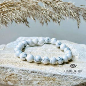 Aesthetic Howlite healing bracelet placed on natural stone, designed for emotional balance, spiritual growth, and anxiety relief.