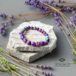 Handmade gemstone bracelet surrounded by dried lavender, enhancing its spiritual and healing properties. A perfect meditation accessory.