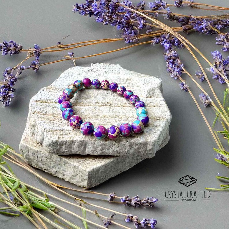 Handmade gemstone bracelet surrounded by dried lavender, enhancing its spiritual and healing properties. A perfect meditation accessory.