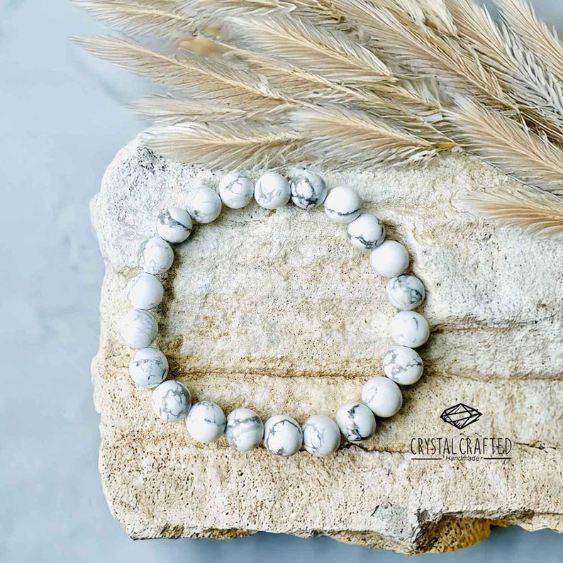 Close-up of a Howlite gemstone bracelet, showcasing white and gray-veined beads on a stretch cord. Perfect for meditation and relaxation.