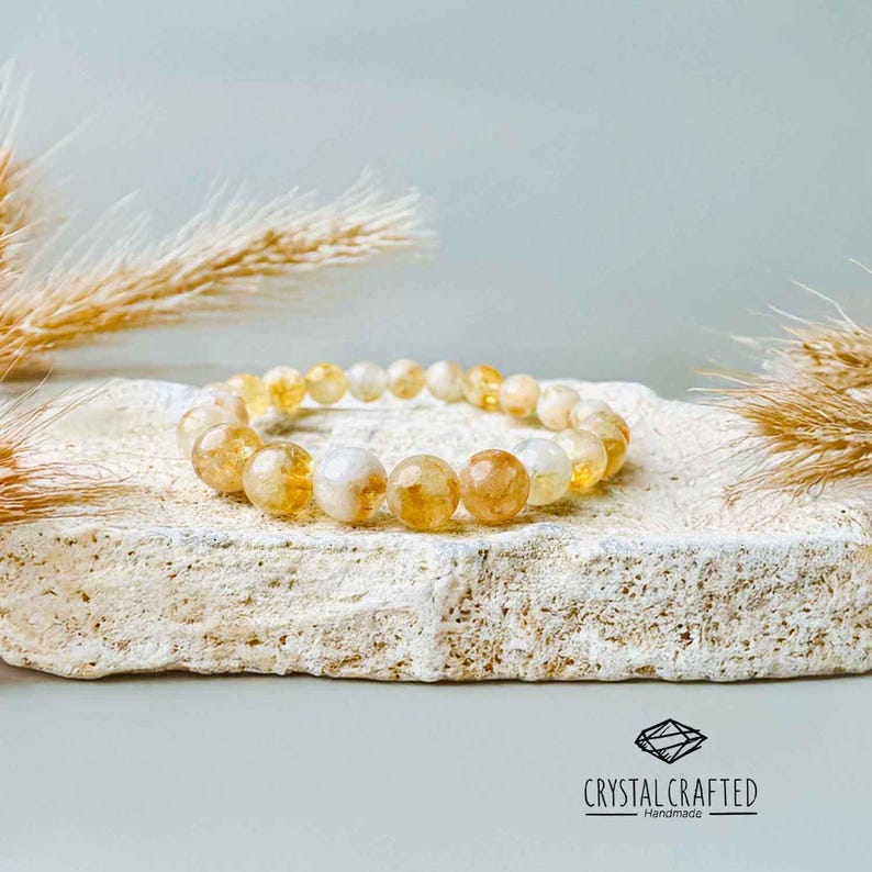 A minimalist, neutral-toned display of the Citrine bracelet on a light stone background, complemented by soft, natural lighting.