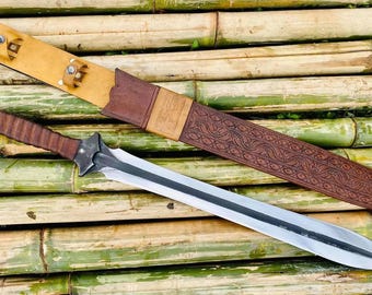 May include: A silver sword with a brown leather scabbard with intricate carvings. The scabbard has a gold-colored tip and a brown leather strap with metal accents.