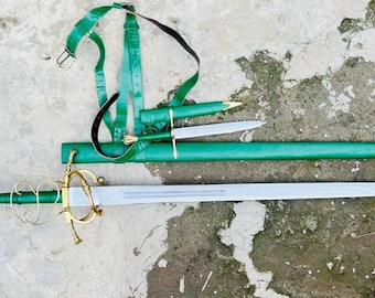 May include: A long sword with a silver blade, a green handle, and a gold-colored ornate hilt, accompanied by a matching green scabbard, a smaller dagger with a green sheath, and a green leather harness with a metal buckle for carrying.