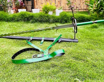 May include: A long sword with a wavy, serrated blade, a green handle, and a black metal crossguard. The sword is accompanied by a black scabbard and a green leather harness with metal buckles, designed for carrying the weapon securely.