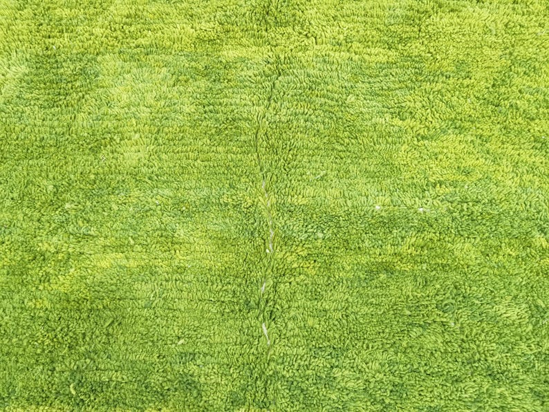 May include: A close-up of a green bath mat with a soft, plush texture.