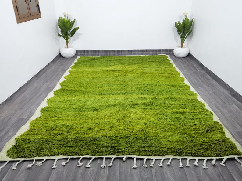 May include: A green shag rug with a white fringe border. The rug has a wavy pattern and is made of soft, fluffy fibers.