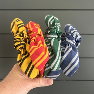 May include: Four fabric headbands in different colors and patterns. The headbands are tied in a knot and are made of a soft, stretchy fabric. The headbands are yellow and black, red and yellow, green and white, and blue and white.