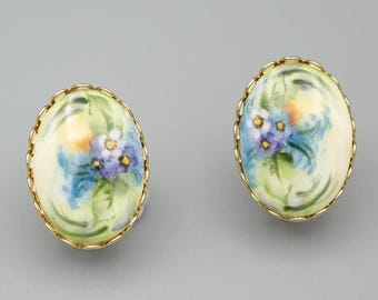 Vintage 1960s hand painted porcelain clip earrings with purple and blue forget-me-not flowers and gold toned metal