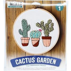 May include: Cactus Garden embroidery project kit with a 15.2 cm hoop, 11 floss colours, printed fabric, needle and instructions. The kit includes three cacti in pots, one with a pink flower.