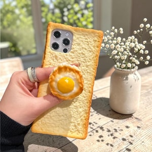 3D Toast Bread iPhone Case with Cookie Egg Handle | Funny Cartoon Phone Cover for iPhone 16, 15, 14, 13, 12 & 11 Pro Max | Cute Holder Case