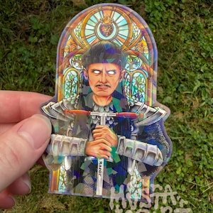 May include: A die-cut sticker featuring a person with glowing white eyes and a moustache, wearing silver armour and holding a T-shaped tool labelled Razor. The background is a colourful stained glass window design with a heart emblem at the top.