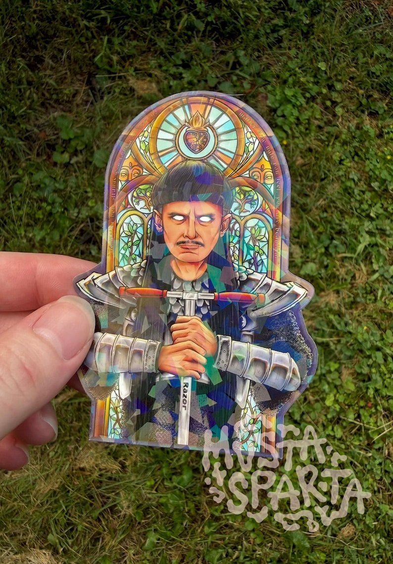 May include: A die-cut sticker featuring a person with glowing white eyes and a moustache, wearing silver armour and holding a T-shaped tool labelled Razor. The background is a colourful stained glass window design with a heart emblem at the top.